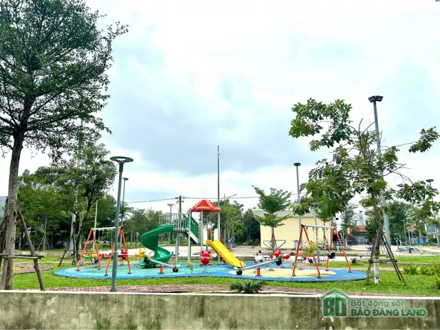 Khu vui chơi trẻ em có cầu trượt và xích đu giữa công viên xanh