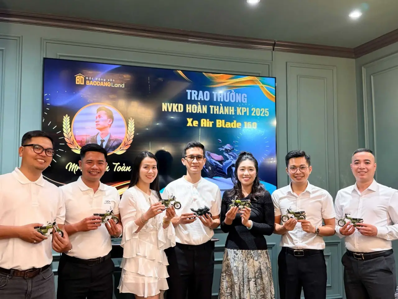Nhân viên Bảo Đăng Land cầm mô hình xe lưu niệm tại Year End Party 2025